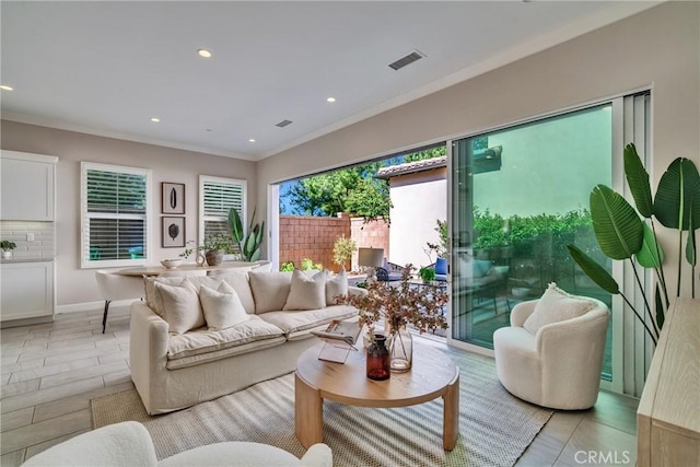 living room with ornamental molding, recessed lighting, visible vents, and baseboards