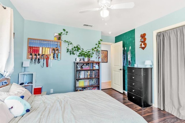 bedroom featuring visible vents, dark wood-type flooring, and ceiling fan