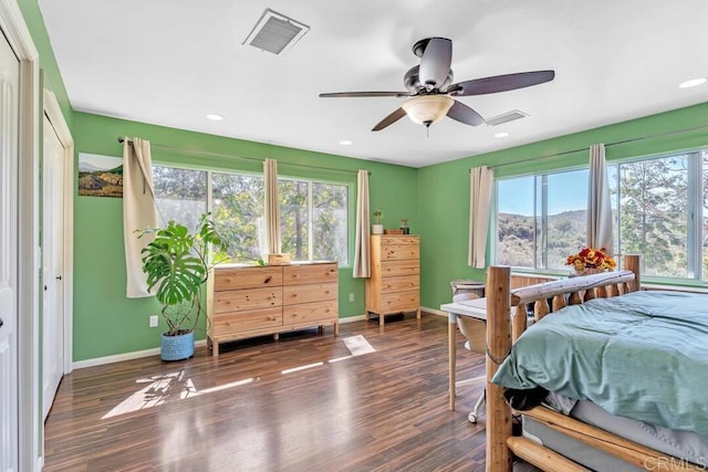 bedroom featuring wood finished floors, visible vents, and baseboards