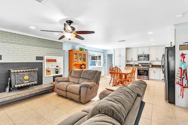 living room with a ceiling fan, visible vents, brick wall, light tile patterned flooring, and recessed lighting