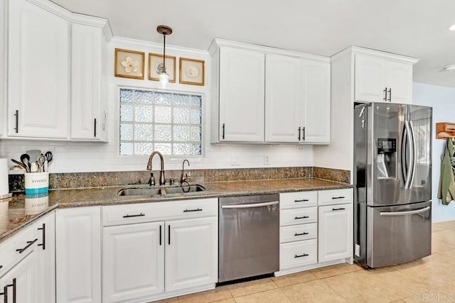 kitchen featuring backsplash, appliances with stainless steel finishes, white cabinetry, and a sink