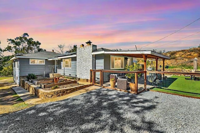 back of property featuring a garden, a patio, and a chimney