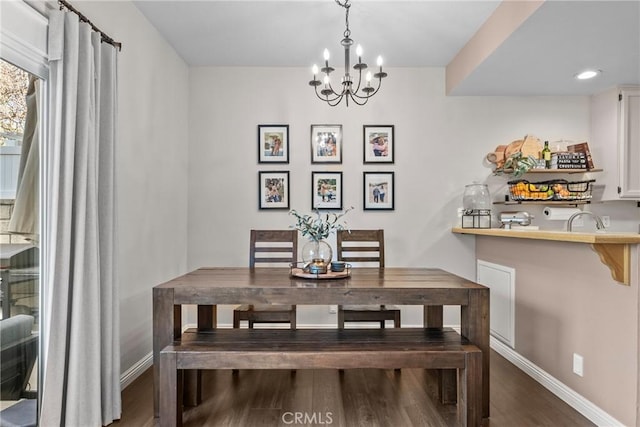 dining space with a notable chandelier, baseboards, and wood finished floors