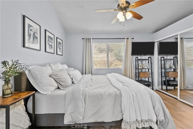 bedroom with access to outside, vaulted ceiling, ceiling fan, and wood finished floors