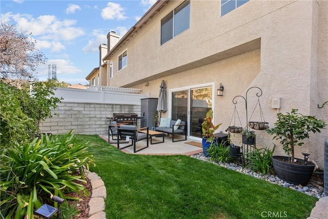 rear view of property featuring a patio, a chimney, fence, a yard, and stucco siding