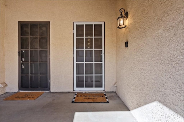 view of exterior entry featuring stucco siding