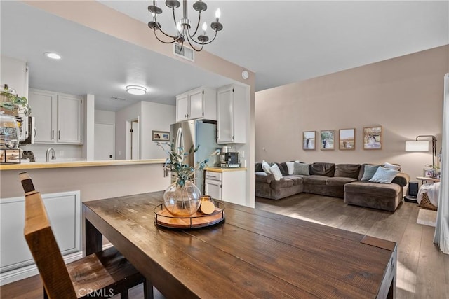 dining area with visible vents, a chandelier, wood finished floors, and recessed lighting