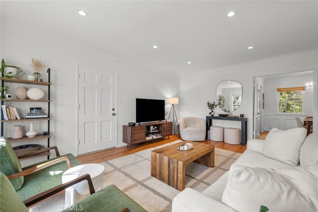 living area featuring light wood-style floors, ornamental molding, and recessed lighting