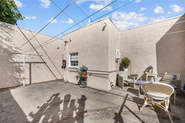 rear view of house featuring a patio and stucco siding