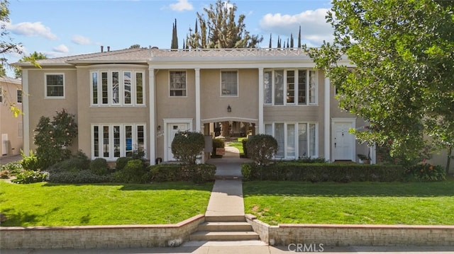 view of front of house with a front yard and stucco siding