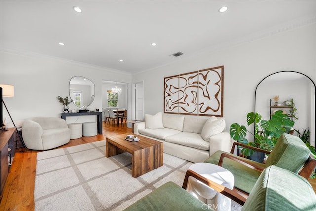 living area featuring ornamental molding, recessed lighting, visible vents, and wood finished floors