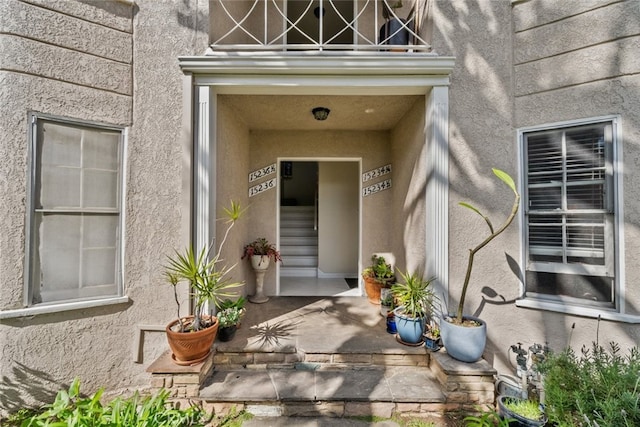 doorway to property featuring a balcony and stucco siding