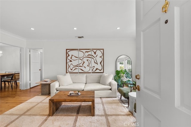 living area with recessed lighting, visible vents, crown molding, and wood finished floors