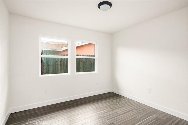 unfurnished room featuring baseboards and wood finished floors