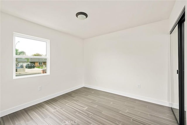 unfurnished bedroom with light wood-style floors, a closet, and baseboards