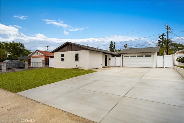 ranch-style house featuring a detached garage, a gate, fence, a front lawn, and stucco siding