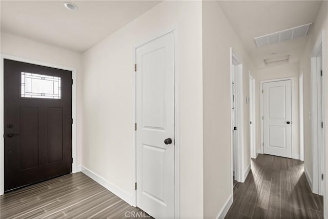 foyer entrance with wood finished floors, visible vents, and baseboards