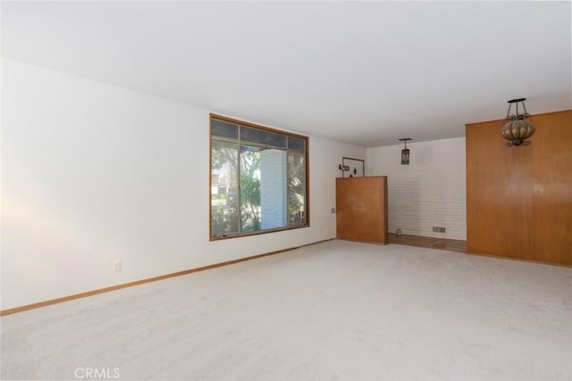 carpeted empty room featuring baseboards