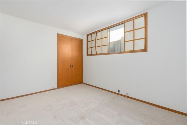 empty room featuring carpet and baseboards