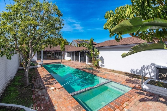 view of pool with a patio area, a fenced backyard, and a pool with connected hot tub