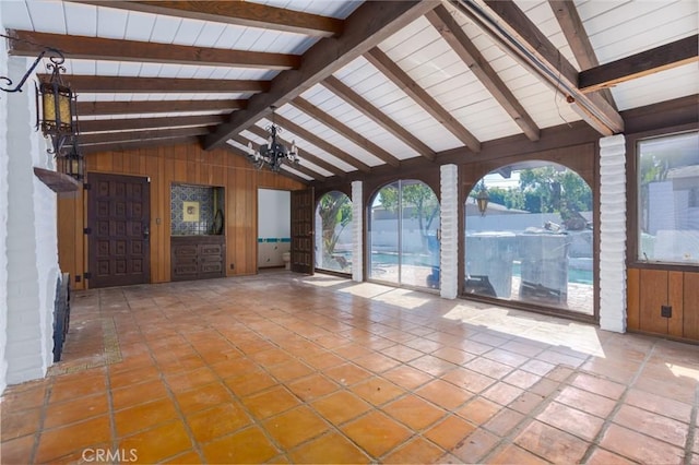 interior space with tile patterned flooring, vaulted ceiling with beams, and wooden walls