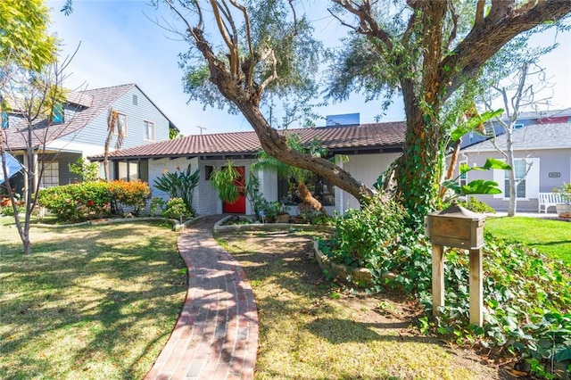 view of front of home with a front yard and a tile roof