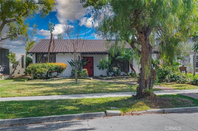 view of front of property featuring a tiled roof and a front yard