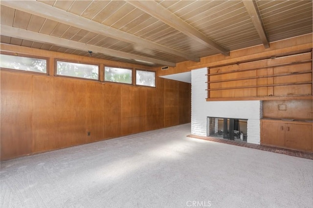 unfurnished living room with a fireplace, carpet flooring, wooden walls, wooden ceiling, and beamed ceiling