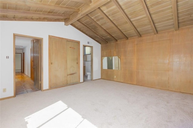 unfurnished bedroom with lofted ceiling with beams, wood ceiling, carpet flooring, and visible vents