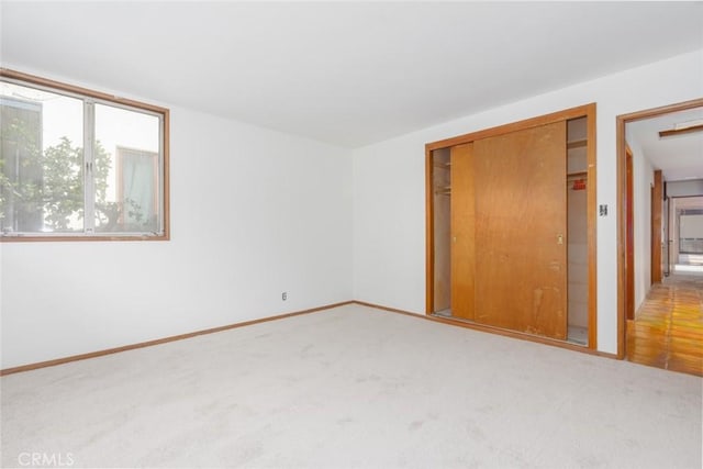 unfurnished bedroom featuring a closet, carpet, and baseboards