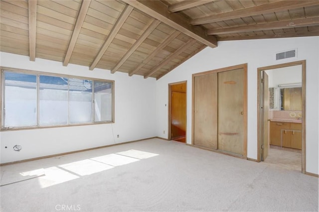 unfurnished bedroom with light colored carpet, visible vents, vaulted ceiling with beams, and baseboards