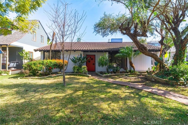 view of front of home featuring a tiled roof and a front lawn