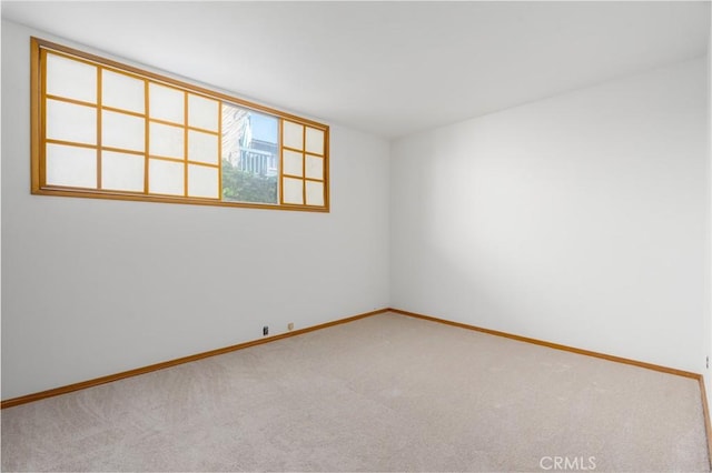 empty room featuring carpet and baseboards