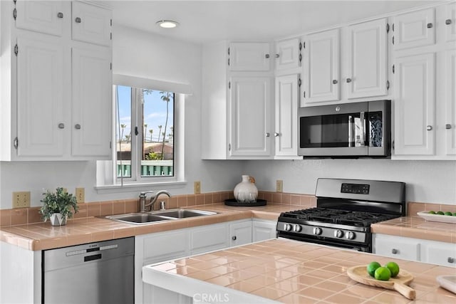 26B Surfside Ave, Surfside, CA 90743 - kitchen with stainless steel appliances, a sink, tile countertops, white cabinets, and recessed lighting