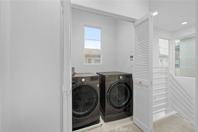 laundry area with laundry area, independent washer and dryer, and tile patterned flooring