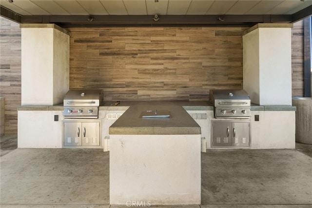 view of patio featuring an outdoor kitchen and a grill