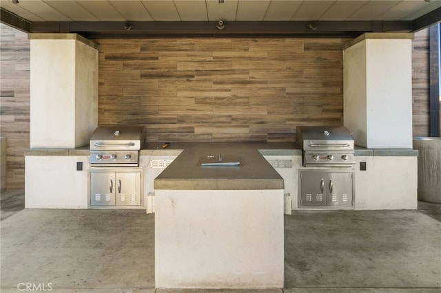 view of patio / terrace with a garage, a grill, and exterior kitchen
