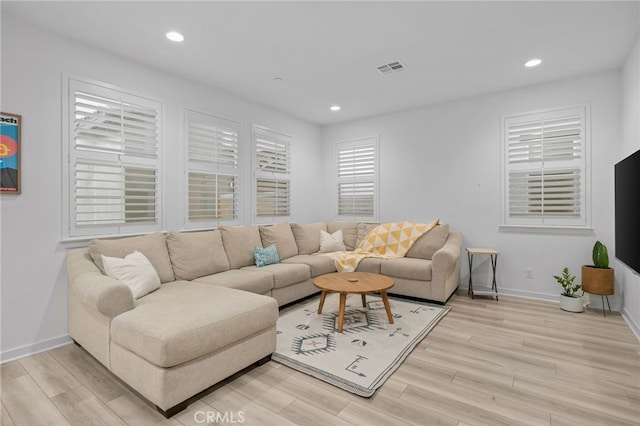 living room featuring light wood-style flooring, visible vents, baseboards, and recessed lighting