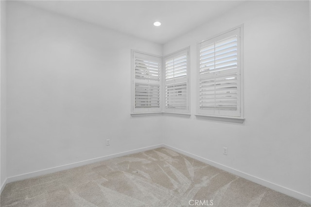 unfurnished room with baseboards, light carpet, and recessed lighting