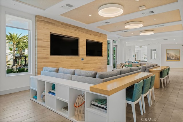 living room with an accent wall, recessed lighting, and visible vents