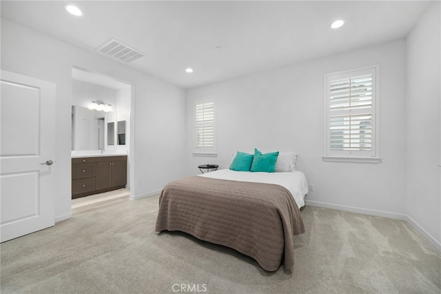bedroom with light colored carpet, visible vents, baseboards, ensuite bathroom, and recessed lighting