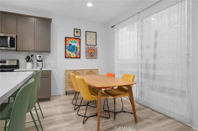 dining space featuring light wood finished floors and recessed lighting