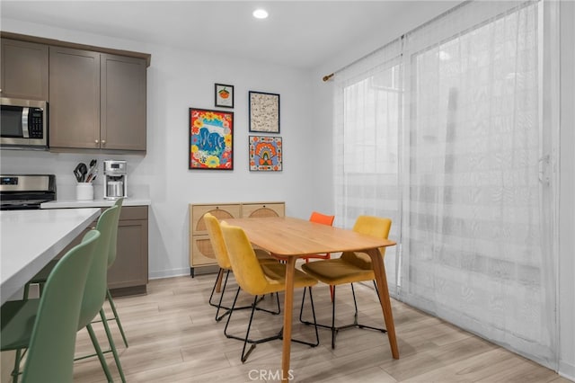 dining space featuring light wood-type flooring, recessed lighting, and baseboards
