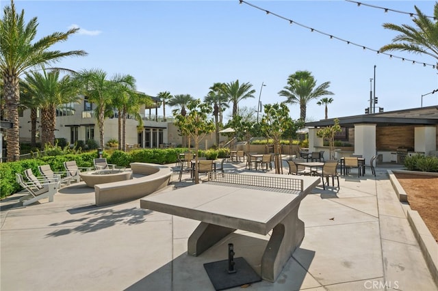 view of property's community with an outdoor fire pit and a patio area