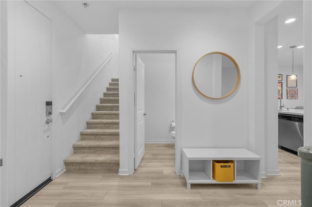 entryway featuring recessed lighting, baseboards, light wood-style flooring, and stairway