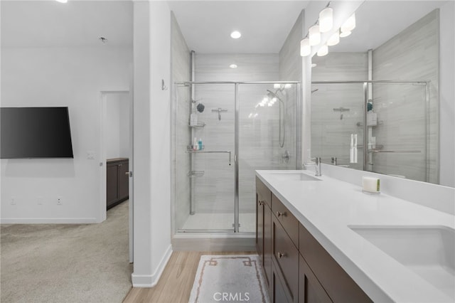 full bath featuring a sink, a shower stall, and double vanity