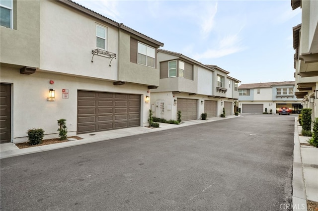exterior space with an attached garage, stucco siding, and a residential view