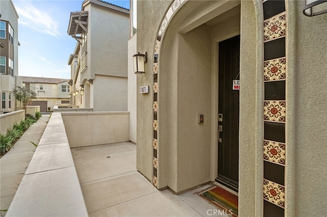 property entrance with a balcony and stucco siding