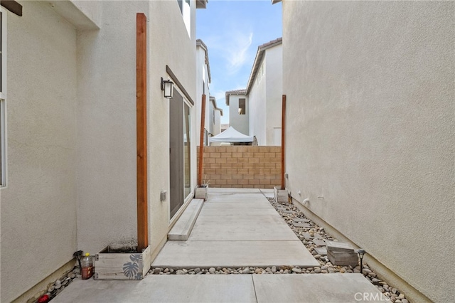 view of side of property featuring fence and stucco siding