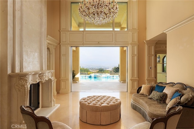 interior space with a fireplace, a high ceiling, light tile patterned flooring, a chandelier, and ornate columns